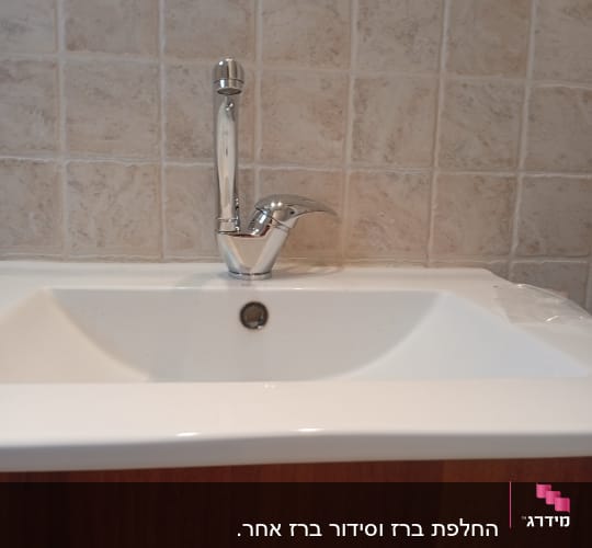 כיור וברז בחדר אמבטיה עם אריחים